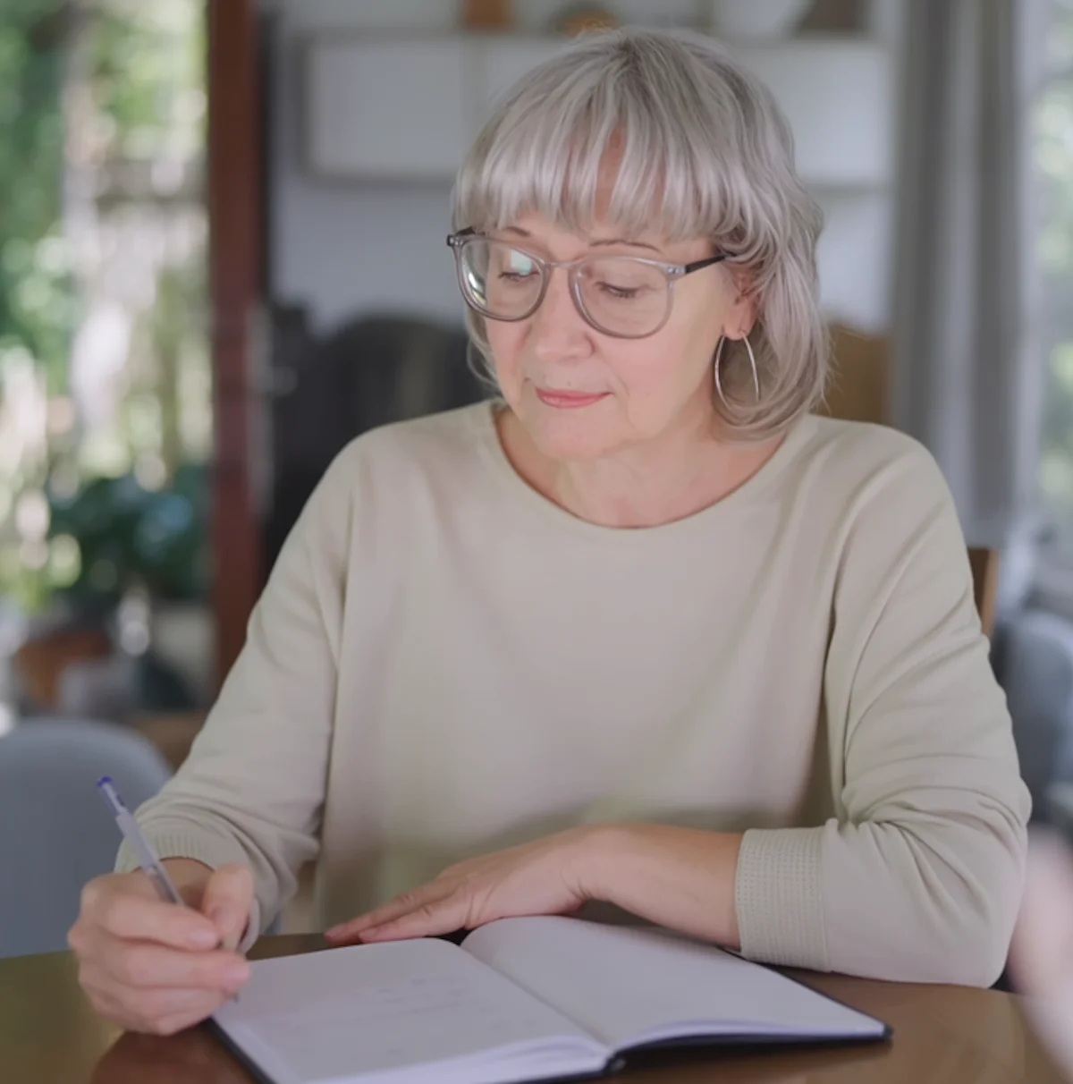 Woman writing notes calmly, reflecting after a relapse and planning next steps