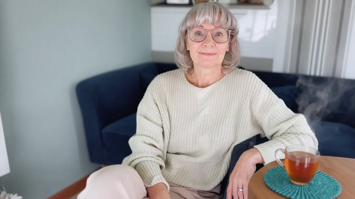 Susan Gast sitting calmly with a cup of tea, representing a relaxed alcohol-free lifestyle