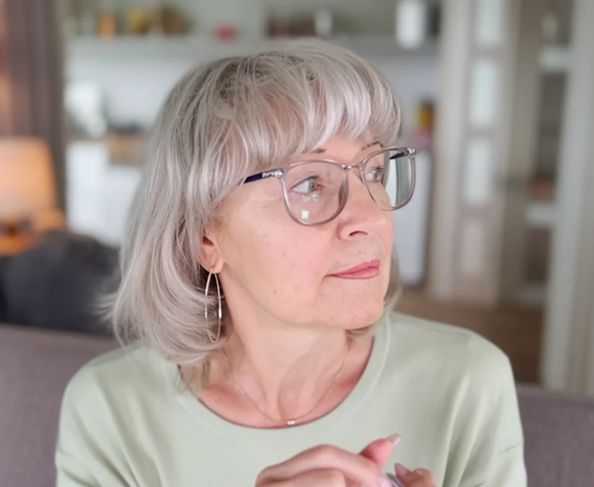 Woman pausing and fidgeting with her fingers, reflecting a familiar evening drinking habit