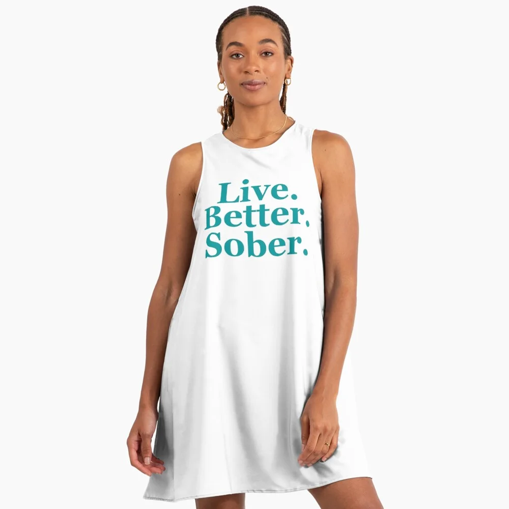 Woman wearing a white “Live. Better. Sober.” typography sleeveless dress.